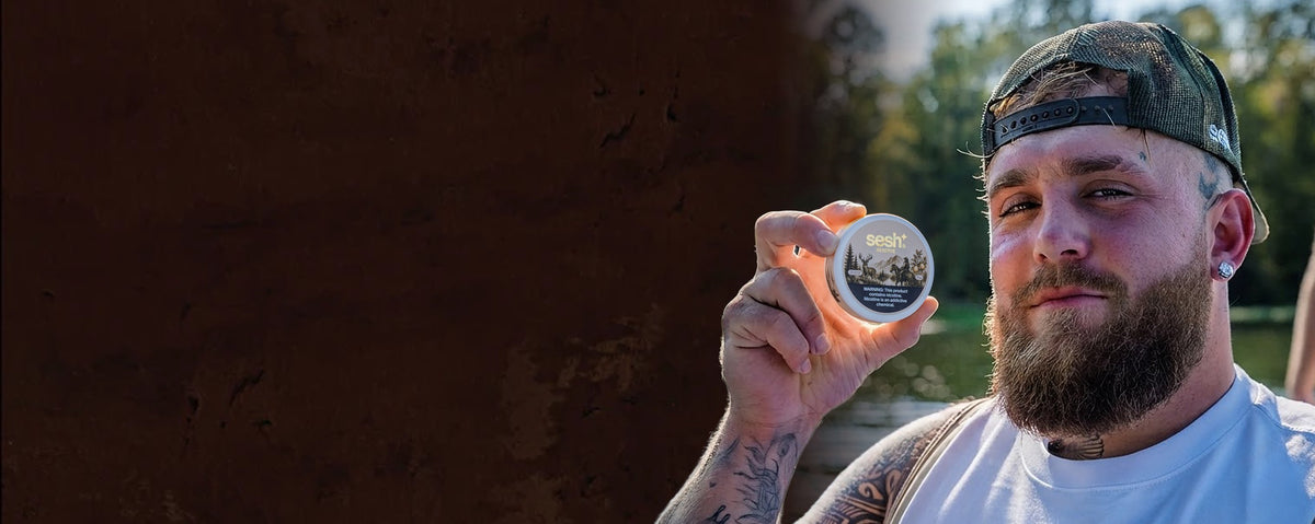 Jake Paul holding a can of Sesh Reserve by the lake
