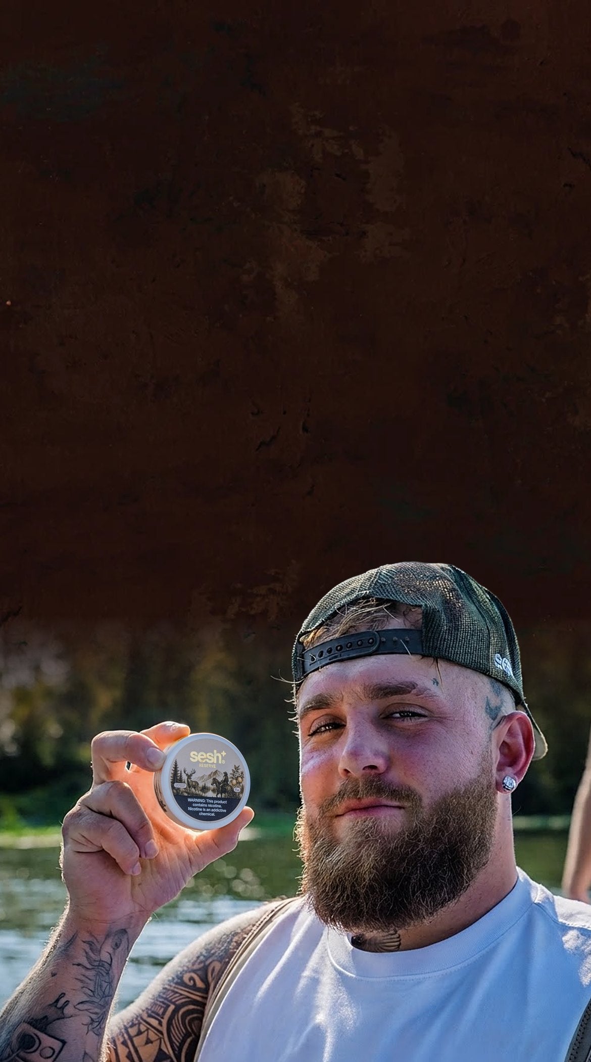 Jake Paul holding a can of Sesh Reserve by the lake